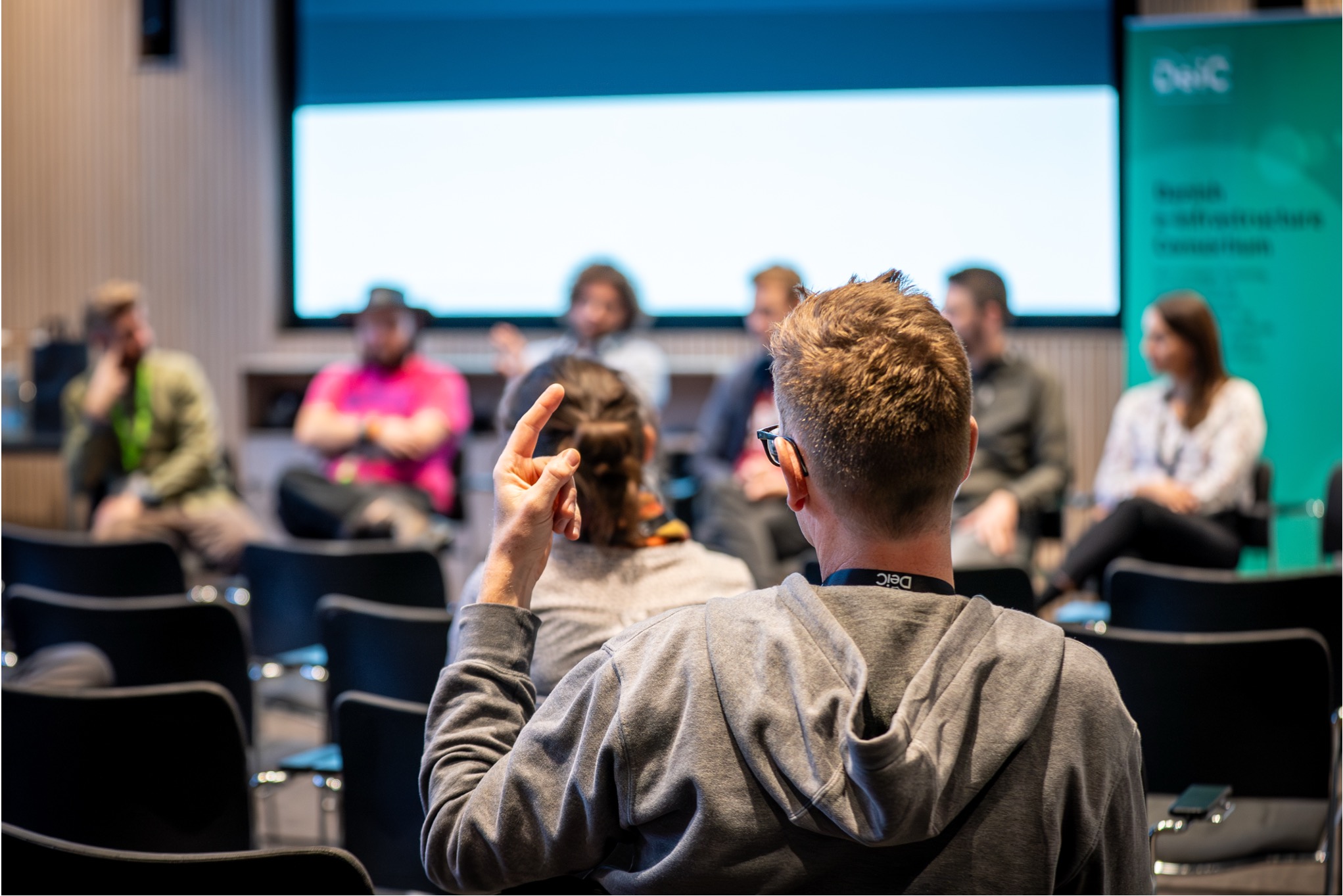 Siddende person med fingeren i vejret