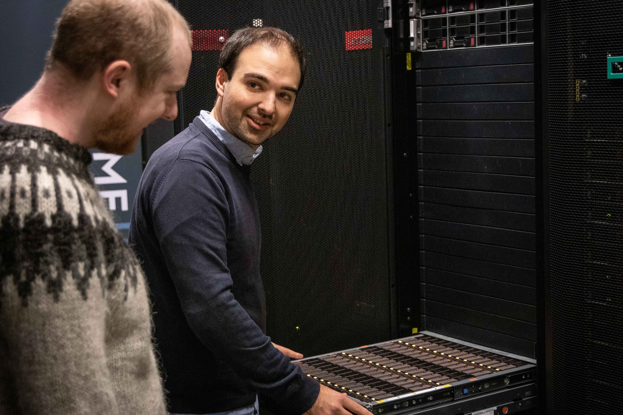 2 personer står ved GenomeDK supercomputer