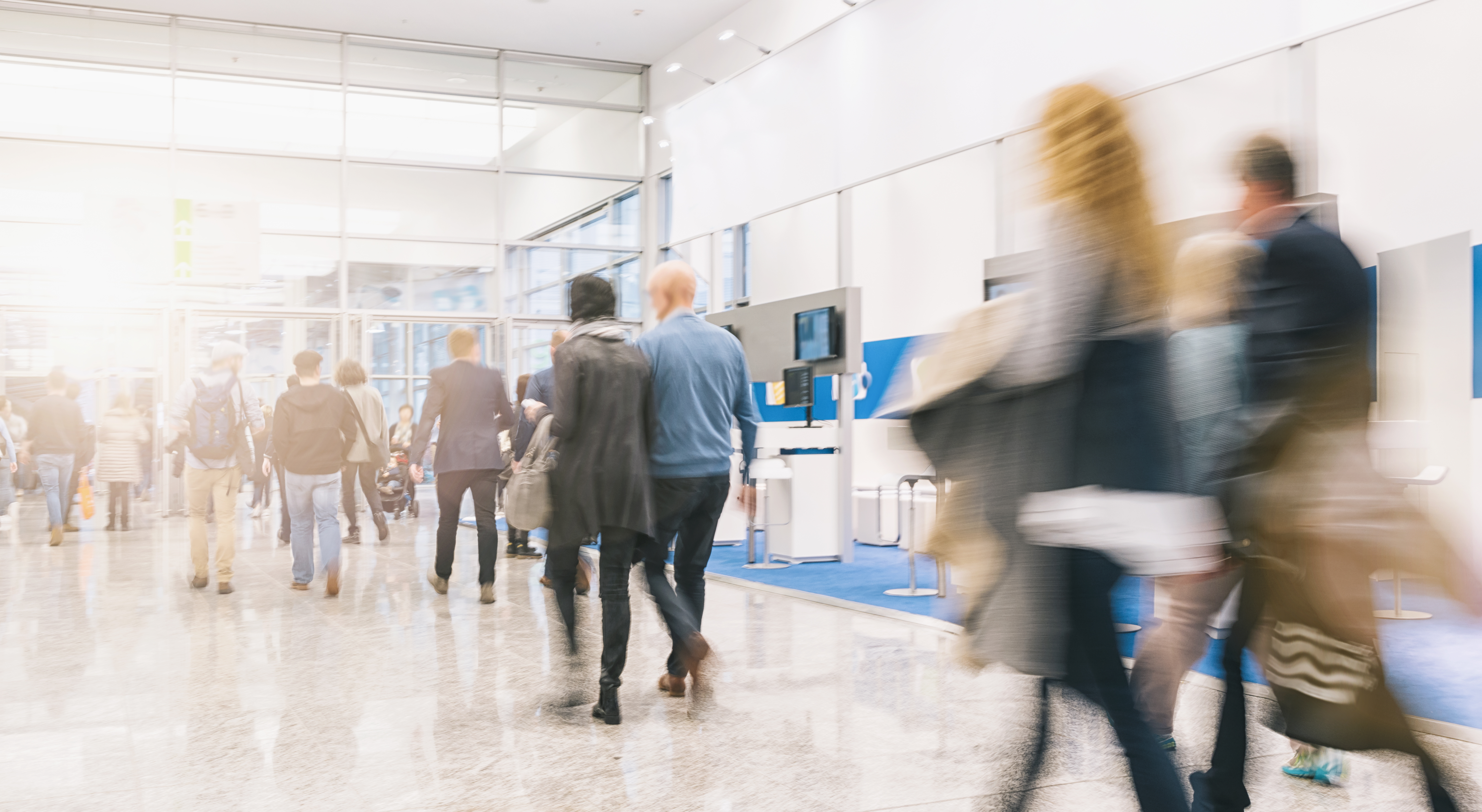 People passing vendors at a conference